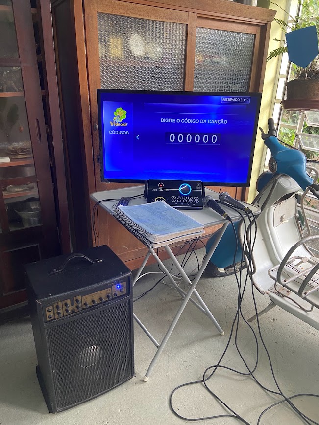 Videokê com catálogo de músicas e caixa amplificada em varanda